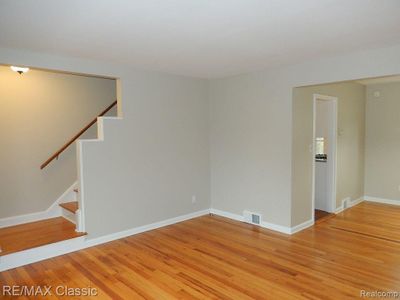 Hardwood floor in living room, dining, & stairway | Image 3