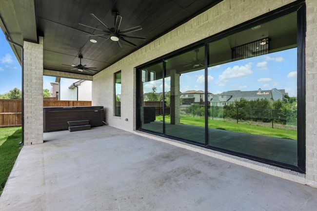 Fenced backyard with a hot tub, a ceiling fan, and a patio area | Image 35