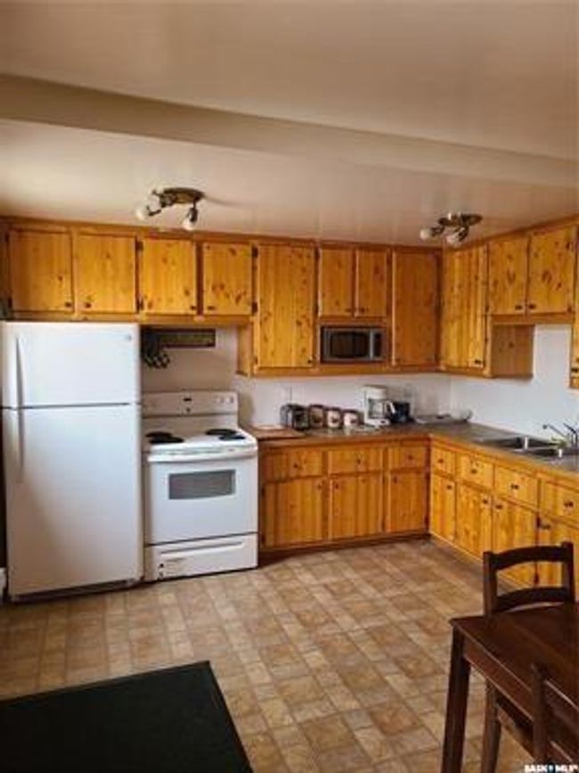 Kitchen with white appliances, sink, and light tile patterned floors | Image 38