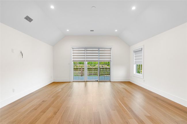 Empty room featuring baseboards, lofted ceiling, light wood-style flooring, and recessed lighting | Image 32
