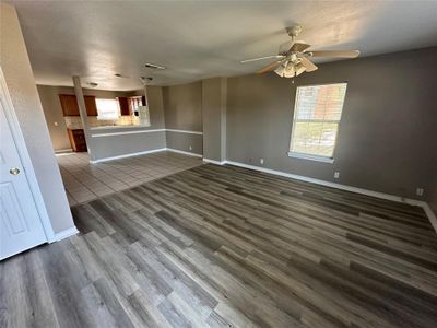 Unfurnished living room with ceiling fan, hardwood / wood-style floors, and a healthy amount of sunlight | Image 3