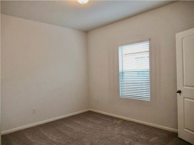 Unfurnished room with dark colored carpet and baseboards | Image 9