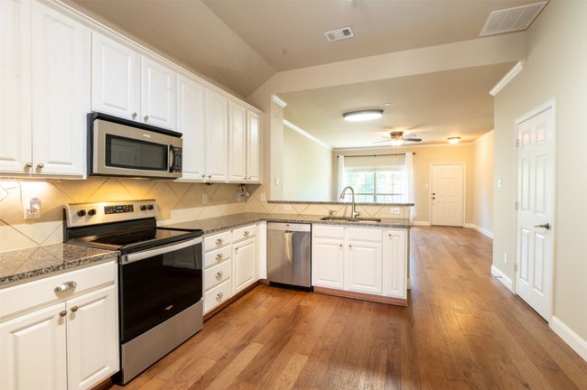 Kitchen with breakfast bar opens to the living room. | Image 5