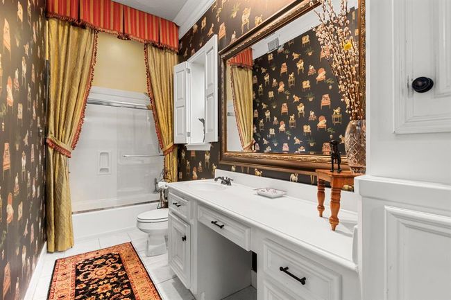 The secondary first floor bedroom en-suite bath features charming wallpaper for an old world feel with a modern glass tub/shower enclosure. The delicate window shutters allow natural light to stream in but can be closed when privacy is desired. | Image 27