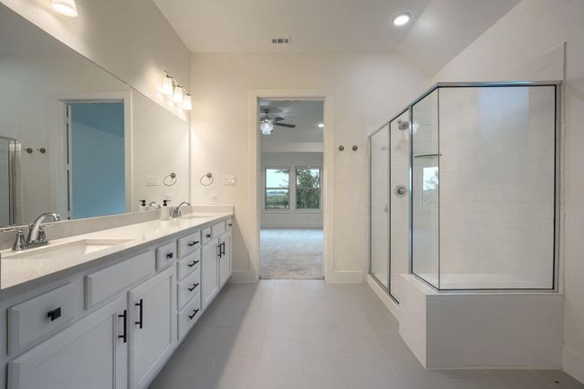 Bathroom with a stall shower, ceiling fan, double vanity, baseboards, and recessed lighting | Image 21