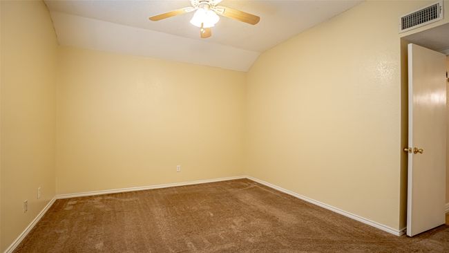 Unfurnished room with carpet flooring, ceiling fan, vaulted ceiling, and baseboards | Image 12