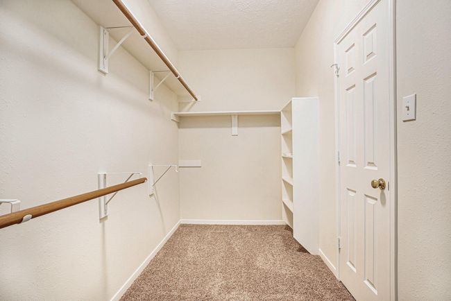 Large walk-in closet in primary ensuite with new carpet. | Image 26