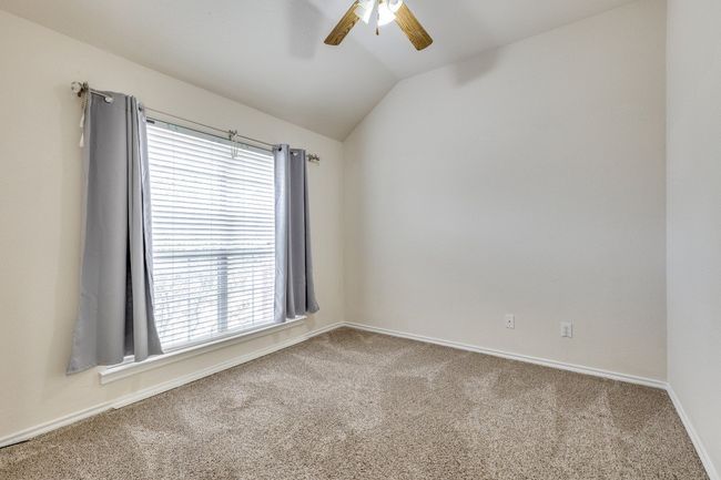 Carpeted empty room with baseboards, lofted ceiling, and ceiling fan | Image 22