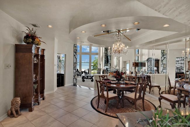 Dining area with recessed lighting, an inviting chandelier, light tile patterned floors, a raised ceiling, and baseboards | Image 5