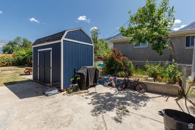 View of patio featuring area for grilling and a storage shed | Image 32