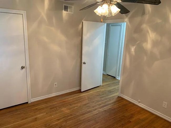 Unfurnished bedroom with baseboards, wood finished floors, and ceiling fan | Image 4