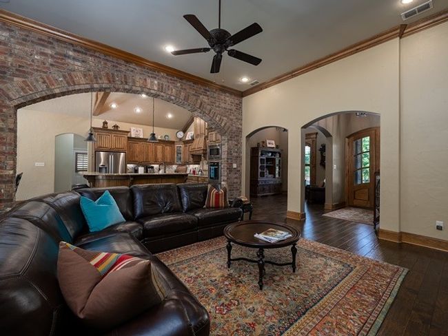 Living room featuring arched walkways, visible vents, dark wood-style floors, and ceiling fan | Image 8