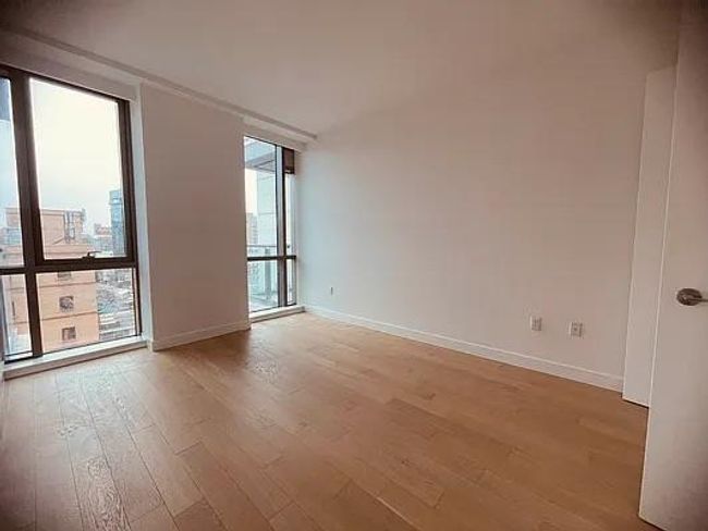 Empty room featuring light wood finished floors, expansive windows, and baseboards | Image 12