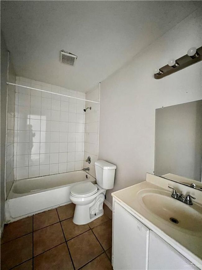 Bathroom with visible vents, toilet, shower / bathing tub combination, tile patterned flooring, and vanity | Image 5