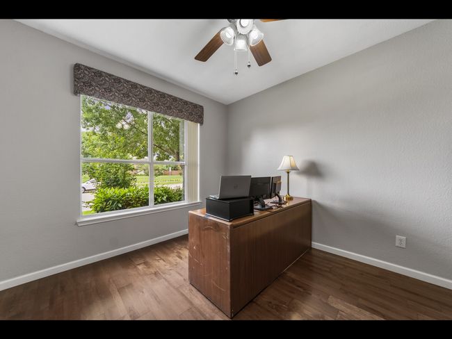 Home office featuring baseboards, a ceiling fan, and wood finished floors | Image 25