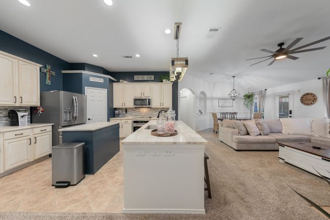 Kitchen with appliances with stainless steel finishes, a center island, arched walkways, backsplash, and recessed lighting | Image 19