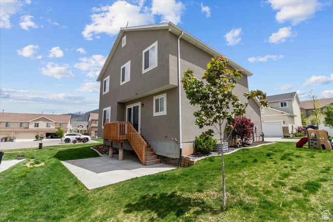 Back of property featuring stucco siding, a residential view, and a yard | Image 6