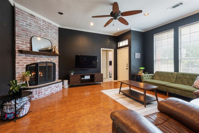 Living room featuring wood finished floors, ceiling fan, recessed lighting, crown molding, and a fireplace | Image 4