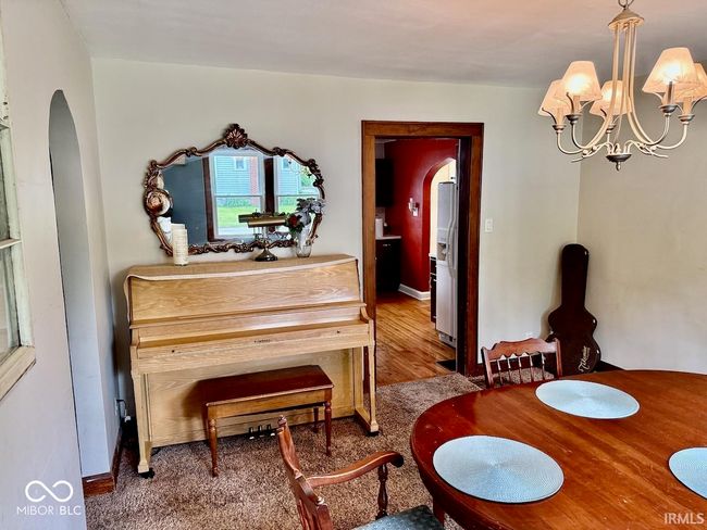 dining area with arched walkways, a chandelier, and wood finished floors | Image 17