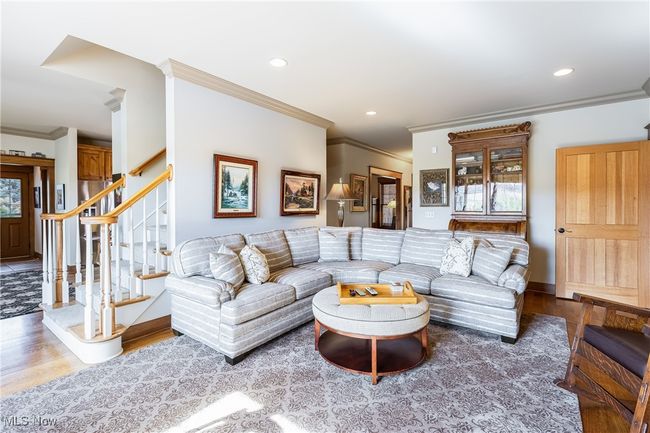 Living room featuring recessed lighting, wood finished floors, baseboards, stairs, and crown molding | Image 21