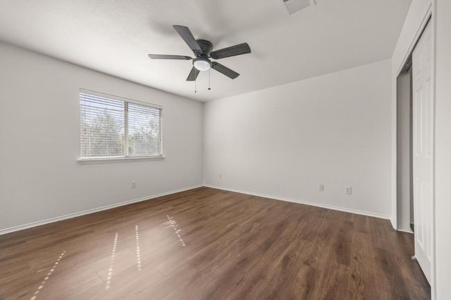 Unfurnished bedroom with baseboards, visible vents, a ceiling fan, and dark wood-style flooring | Image 20