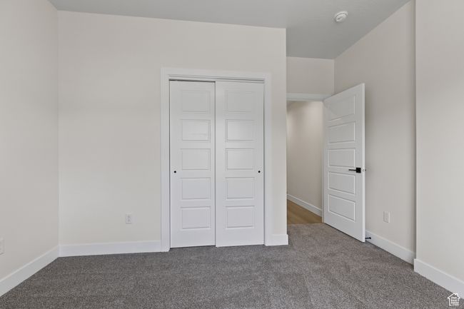 Unfurnished bedroom with carpet, a closet, and baseboards | Image 21