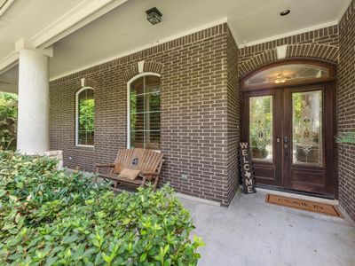 At the front entry there's a long covered porch. Enjoy sitting here with your morning coffee or greeting your guests from here. | Image 3