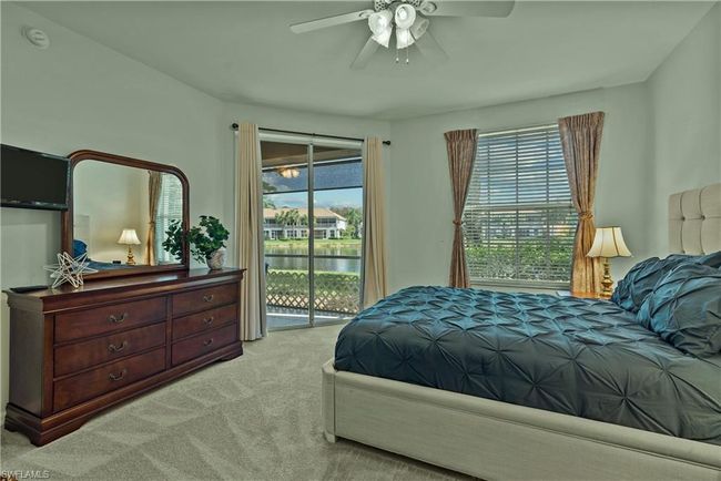 Bedroom with light carpet, access to outside, ceiling fan, and a water view | Image 12