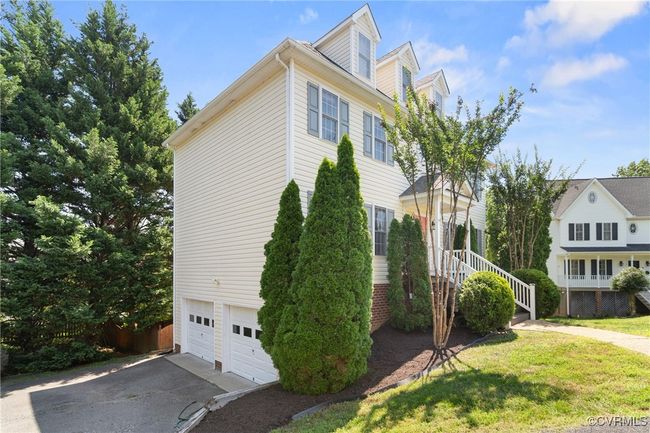 View of side of property featuring an attached garage, asphalt driveway, and a lawn | Image 35