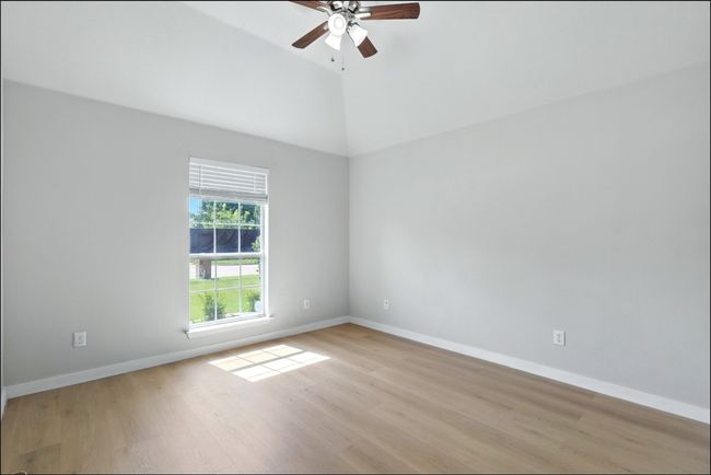 Spare room with a ceiling fan, light wood finished floors, and high vaulted ceiling | Image 11