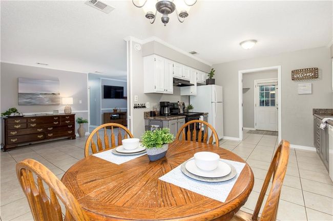 Dining room featuring light tile floors, a chandelier, and wine cooler | Image 7