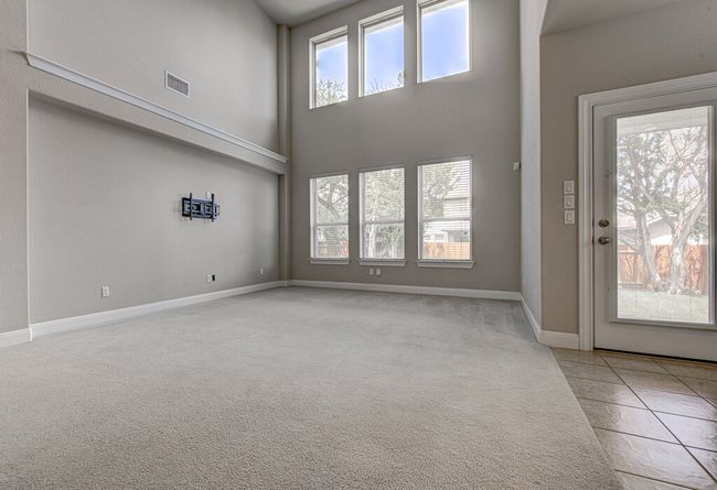 Carpeted foyer entrance featuring a high ceiling and baseboards | Image 11