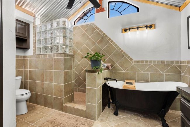 Full bath with tile walls, a freestanding tub, toilet, walk in shower, and tile patterned flooring | Image 15