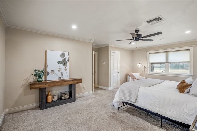 Bedroom with light carpet, crown molding, visible vents, and baseboards | Image 34