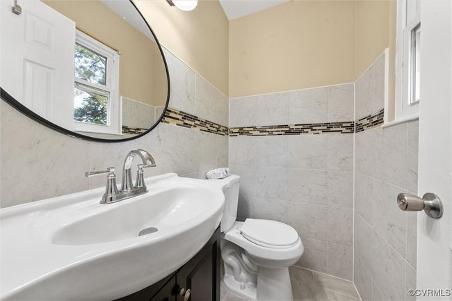 Bathroom with tile walls, wainscoting, toilet, and vanity | Image 23