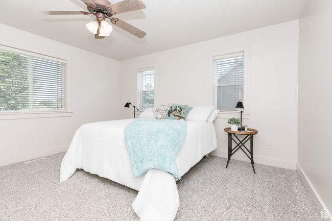 Bedroom with light colored carpet and a ceiling fan | Image 10