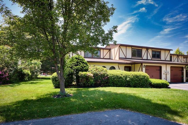 View of front of home with stucco siding, a front lawn, an attached garage, and asphalt driveway | Image 30
