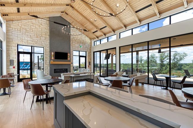 Kitchen featuring wooden ceiling with exposed beams, high vaulted ceiling, light wood-type flooring, a fireplace, and a chandelier | Image 35