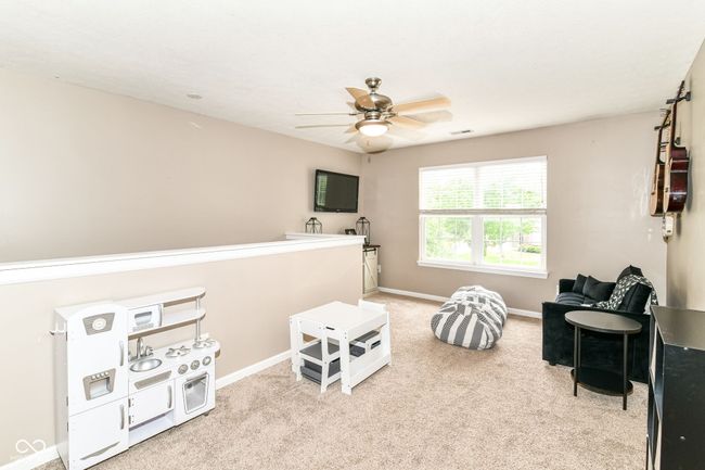 sitting room with ceiling fan, carpet floors, and baseboards | Image 22
