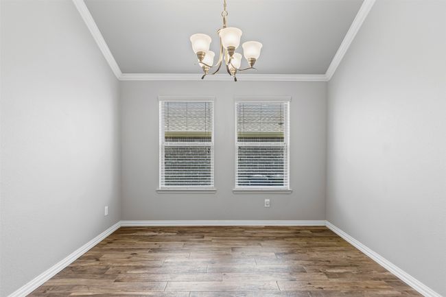 Office or formal dining room with a chandelier, wood finished floors, and crown molding | Image 10
