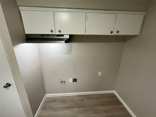 Laundry area with dark wood finished floors and baseboards | Image 8