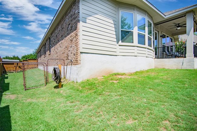 View of side of property featuring brick siding and a ceiling fan | Image 19