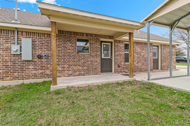 Property entrance with a lawn, brick siding, and a shingled roof | Image 18