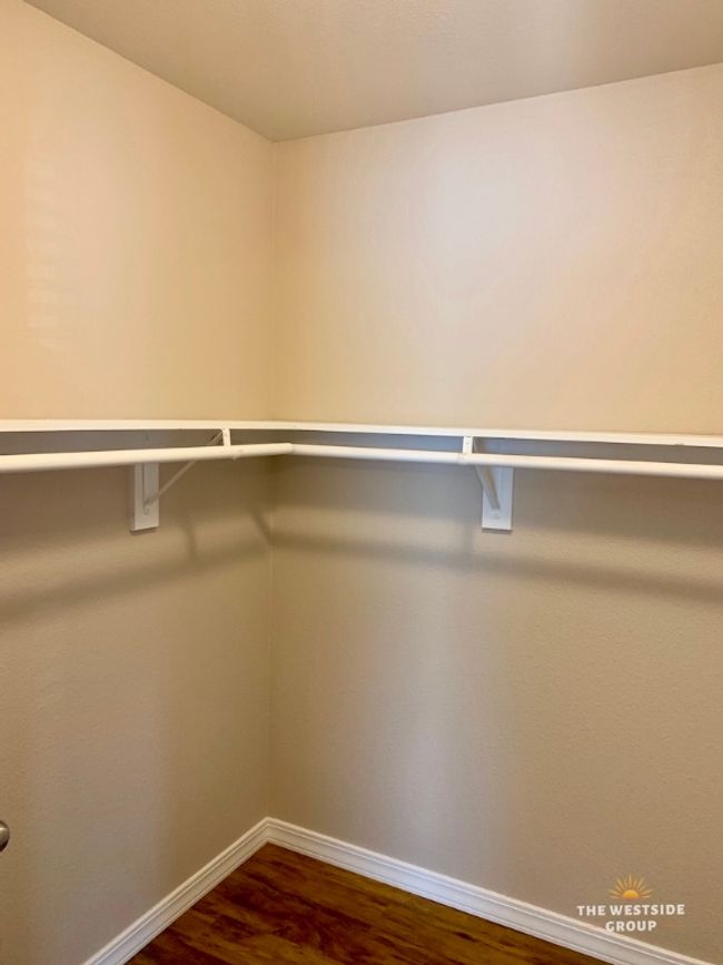 Walk in closet with dark wood finished floors | Image 5