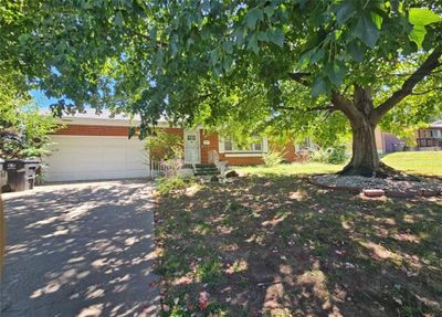 Obstructed view of property with a garage and a front lawn | Image 1