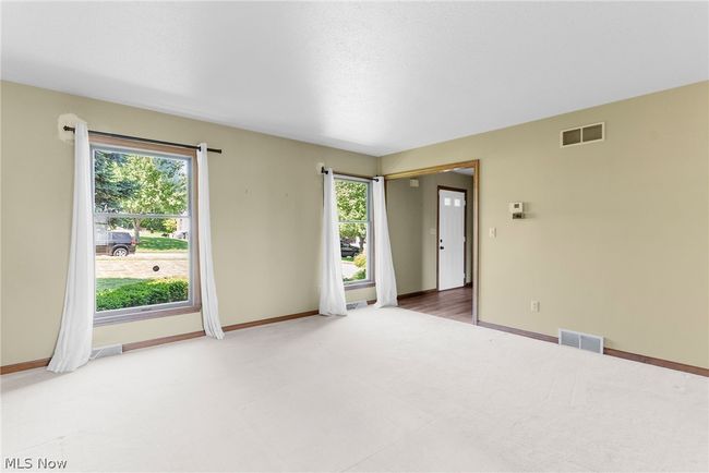 Unfurnished room featuring carpet floors and a wealth of natural light | Image 6