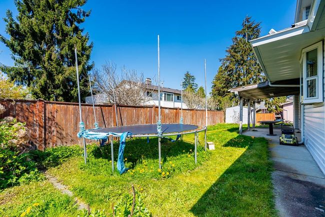 View of yard with a trampoline, an outbuilding, a fenced backyard, and a storage unit | Image 27