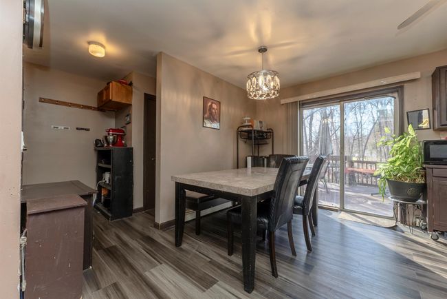 Dining space featuring dark wood-type flooring and a notable chandelier | Image 10