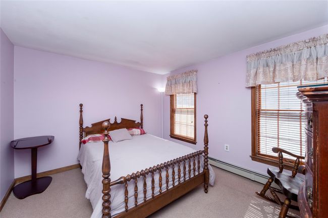 Bedroom featuring multiple windows, carpet, and baseboard heating | Image 31