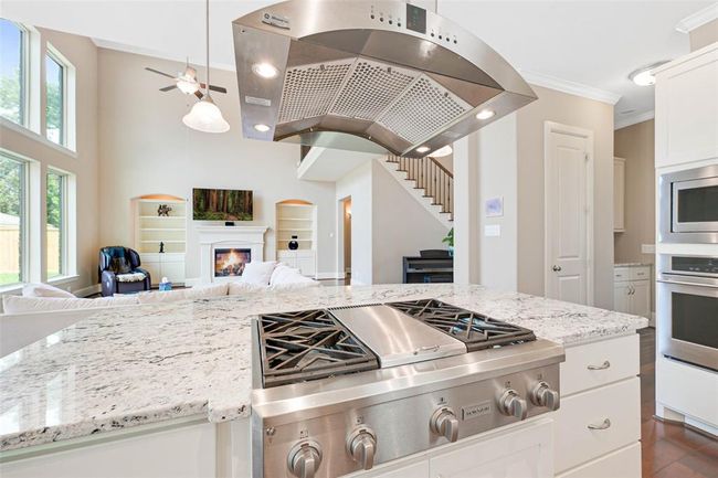 Open to the living room with built-in shelving and views of the upstairs landing, creating a spacious and connected feel. | Image 14